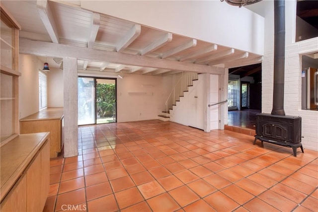 1878 Molino Ave N, Signal Hill, CA 90755 - unfurnished living room with a wood stove, beam ceiling, light tile patterned floors, and stairs