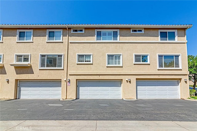 25748 Perlman Pl Unit B, Stevenson Ranch, CA 91381 - rear view of property with stucco siding and a garage