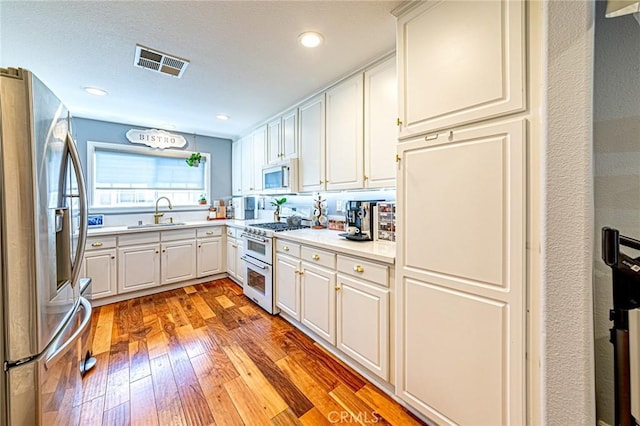 25748 Perlman Pl Unit B, Stevenson Ranch, CA 91381 - kitchen featuring stainless steel fridge with ice dispenser, double oven range, white microwave, light wood-style flooring, and light countertops
