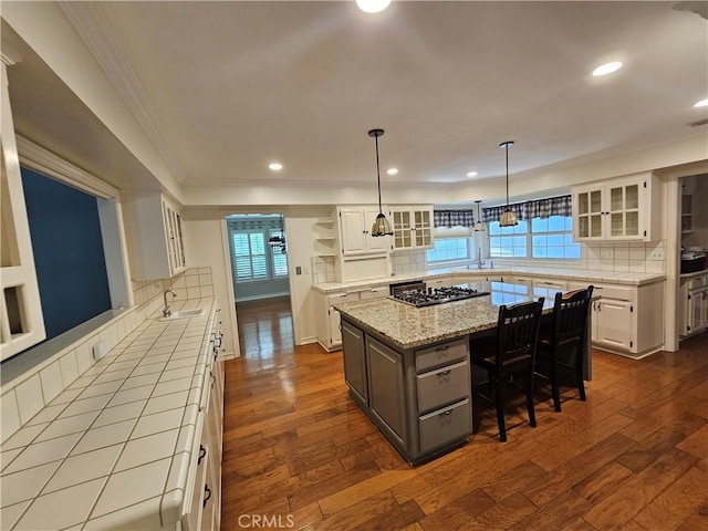 41710 Crispi Ln, Lancaster, CA 93536 - kitchen with white cabinets, decorative backsplash, a kitchen island, dark wood-style floors, and ornamental molding