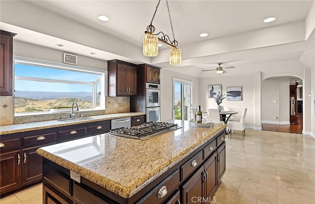 870 Avenida Acapulco, San Clemente, CA 92672 - kitchen featuring stainless steel appliances, a ceiling fan, tasteful backsplash, a center island, and pendant lighting