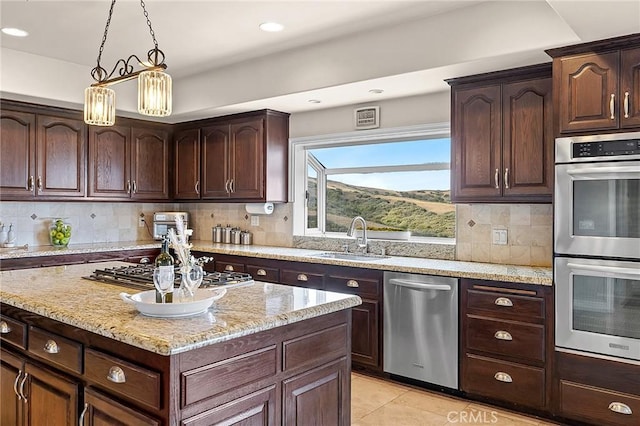 870 Avenida Acapulco, San Clemente, CA 92672 - kitchen with stainless steel appliances, light tile patterned floors, light stone countertops, pendant lighting, and dark brown cabinets