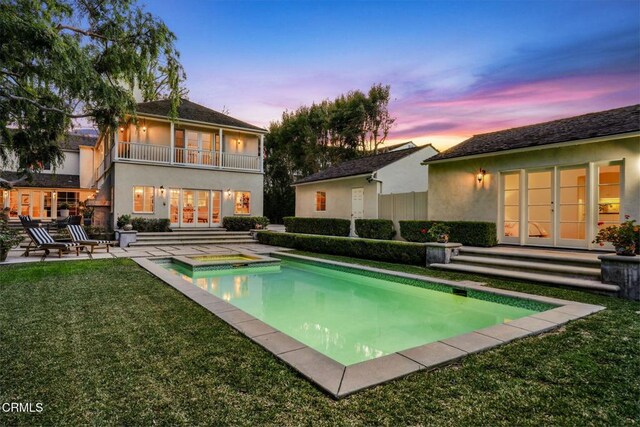 980 El Campo Dr, Pasadena, CA 91107 - back of property at dusk featuring french doors, a balcony, stucco siding, a patio area, and a yard
