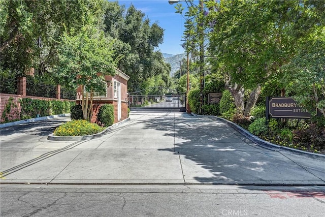 247 El Cielo Ln, Bradbury, CA 91008 - view of concrete road with curbs, a gate, a gated entry, and a mountain view