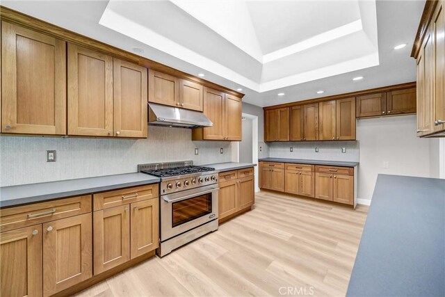 247 El Cielo Ln, Bradbury, CA 91008 - kitchen with high end stove, under cabinet range hood, recessed lighting, light wood-style flooring, and brown cabinetry