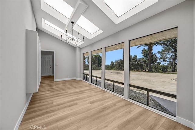 247 El Cielo Ln, Bradbury, CA 91008 - empty room featuring a skylight, vaulted ceiling, and light wood-type flooring