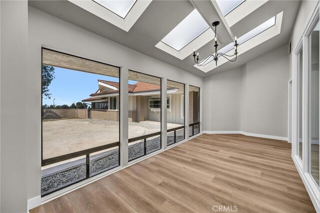 247 El Cielo Ln, Bradbury, CA 91008 - unfurnished room with a skylight, wood finished floors, a chandelier, and lofted ceiling