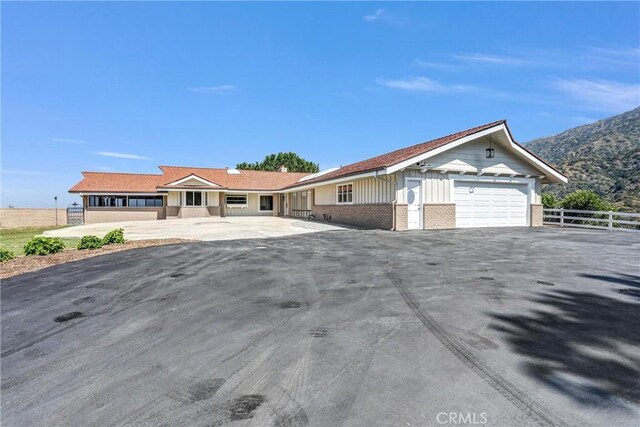 247 El Cielo Ln, Bradbury, CA 91008 - ranch-style house with brick siding, an attached garage, a mountain view, and board and batten siding