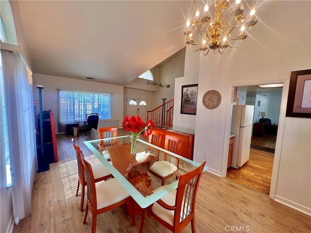 18725 Dallas Ave, Riverside, CA 92508 - dining area with light wood-style flooring, a chandelier, high vaulted ceiling, and stairs