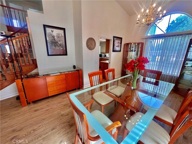 18725 Dallas Ave, Riverside, CA 92508 - dining space with light wood-style floors, a chandelier, a high ceiling, and stairway