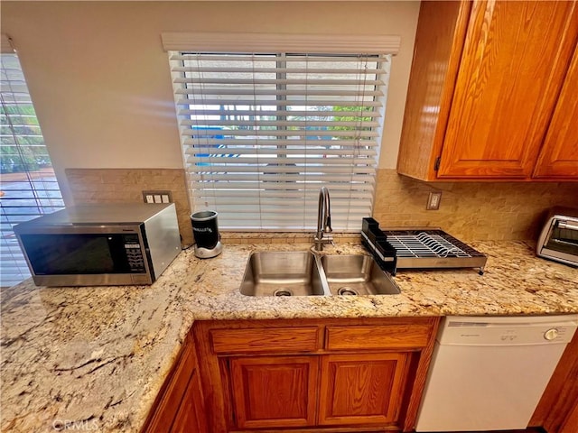 18725 Dallas Ave, Riverside, CA 92508 - kitchen with stainless steel microwave, dishwasher, tasteful backsplash, brown cabinets, and light stone counters