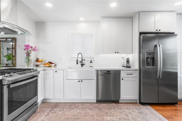 2109 Cathryn Dr, Rosemead, CA 91770 - kitchen with stainless steel appliances, wall chimney range hood, light countertops, white cabinets, and recessed lighting