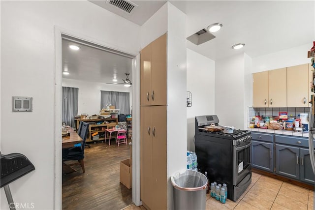 1323 W 6th St, Pomona, CA 91766 - kitchen with stainless steel gas stove, tile counters, light wood-style flooring, and backsplash