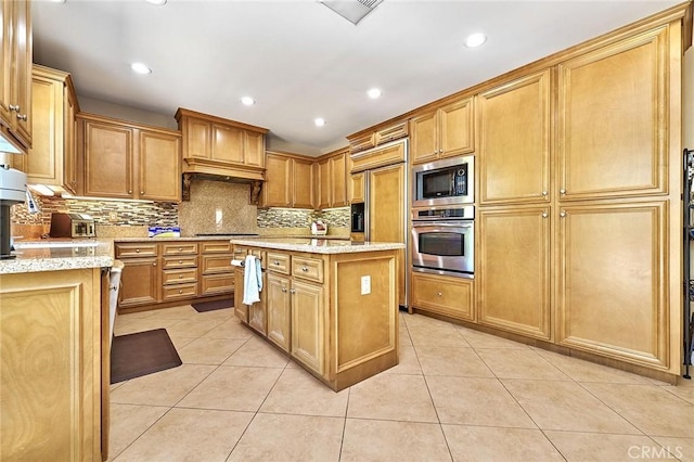524 S Petunia St, La Habra, CA 90631 - kitchen with built in appliances, light tile patterned floors, decorative backsplash, light stone countertops, and a center island
