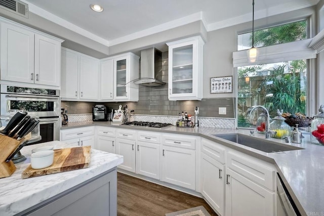 1709 Blackbird Cir, Carlsbad, CA 92011 - kitchen with wall chimney range hood, stainless steel appliances, ornamental molding, recessed lighting, and white cabinets