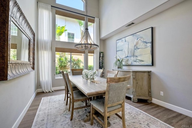 1709 Blackbird Cir, Carlsbad, CA 92011 - dining space featuring healthy amount of natural light, a chandelier, a towering ceiling, and wood finished floors