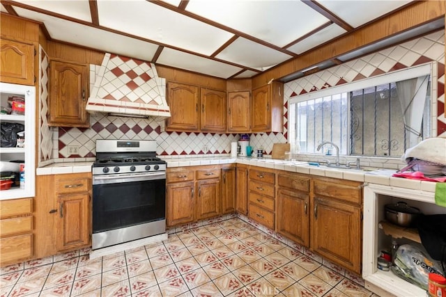 2005 Magnolia Ave, Los Angeles, CA 90007 - kitchen featuring gas stove, custom exhaust hood, decorative backsplash, and brown cabinetry