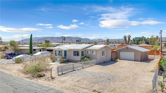 74417 Maricopa Dr Unit 29, Palms, CA 92277 - single story home featuring dirt driveway, a garage, a mountain view, an outdoor structure, and stucco siding