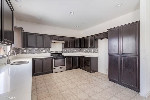 3720 Mount Whitney Ave, Rosamond, CA 93560 - kitchen with stainless steel gas range oven, under cabinet range hood, light flooring, light countertops, and dark brown cabinetry