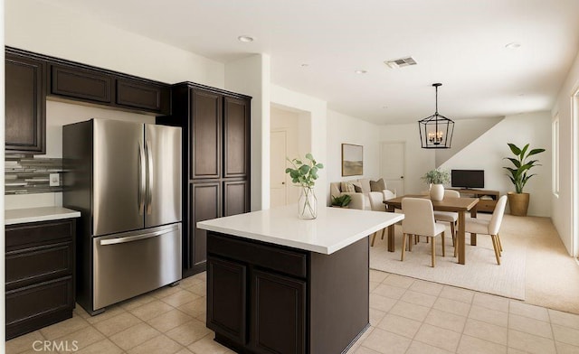 3720 Mount Whitney Ave, Rosamond, CA 93560 - kitchen with freestanding refrigerator, light countertops, open floor plan, a chandelier, and tasteful backsplash
