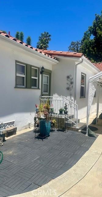 13621 Erwin St, Van Nuys, CA 91401 - rear view of property with stucco siding, a tile roof, and a patio