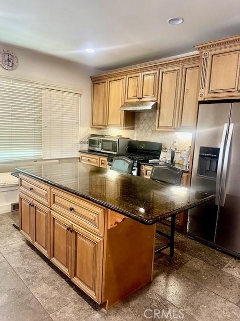 13621 Erwin St, Van Nuys, CA 91401 - kitchen with stainless steel fridge, under cabinet range hood, gas range oven, tasteful backsplash, and dark stone countertops