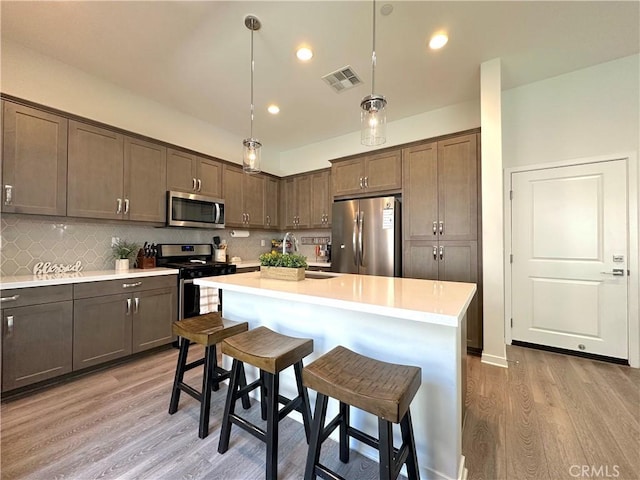 4173 Horvath St Unit 104, Corona, CA 92883 - kitchen featuring stainless steel appliances, light wood-style floors, light countertops, backsplash, and recessed lighting