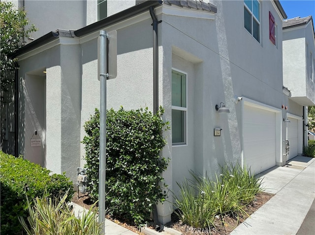 4173 Horvath St Unit 104, Corona, CA 92883 - view of home's exterior with stucco siding, a garage, and driveway