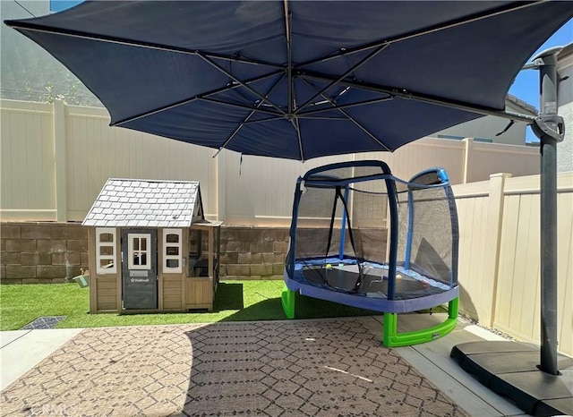 4173 Horvath St Unit 104, Corona, CA 92883 - view of patio with a trampoline and a storage unit