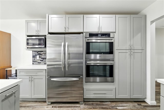 3101 Maple Ave, Fullerton, CA 92835 - kitchen with appliances with stainless steel finishes, light countertops, wood finished floors, decorative backsplash, and gray cabinets