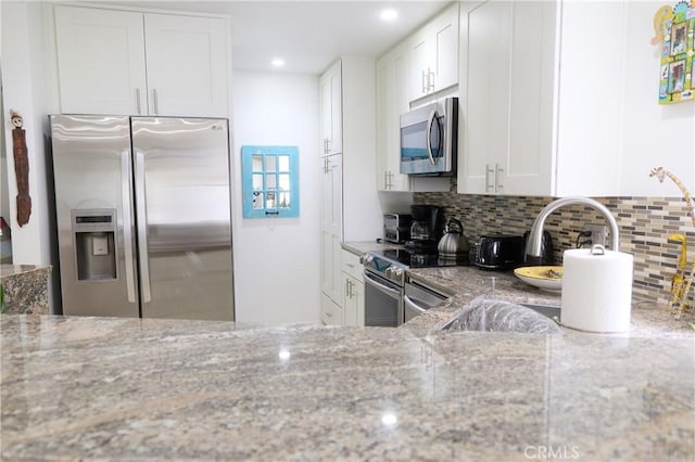 8482 Via Sonoma Unit 18, La Jolla, CA 92037 - kitchen with stainless steel appliances, light stone counters, backsplash, white cabinetry, and recessed lighting