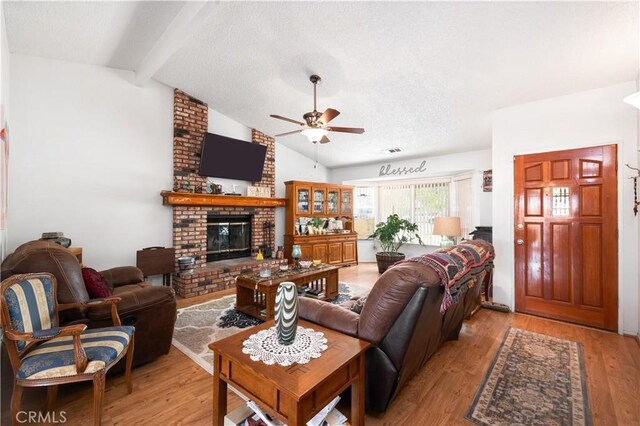 14551 Jelan Ave, Apple Valley, CA 92307 - living room featuring a ceiling fan, a fireplace, light wood-type flooring, and a textured ceiling