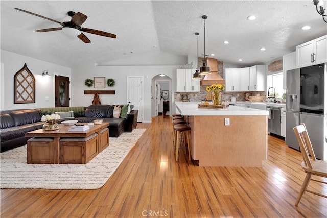 7733 Pismo Ave, Hesperia, CA 92345 - kitchen with stainless steel appliances, open floor plan, a center island, arched walkways, and vaulted ceiling