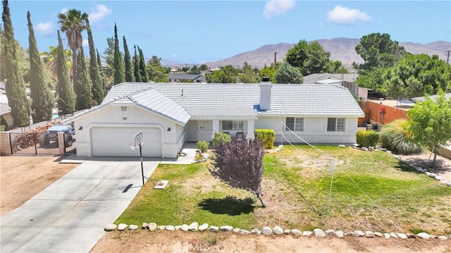 7733 Pismo Ave, Hesperia, CA 92345 - single story home with a tile roof, a garage, concrete driveway, a mountain view, and stucco siding