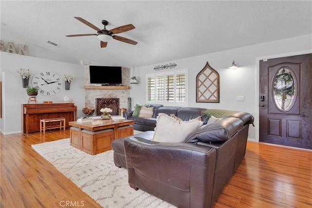 7733 Pismo Ave, Hesperia, CA 92345 - living area with ceiling fan, light wood-type flooring, a fireplace, and vaulted ceiling