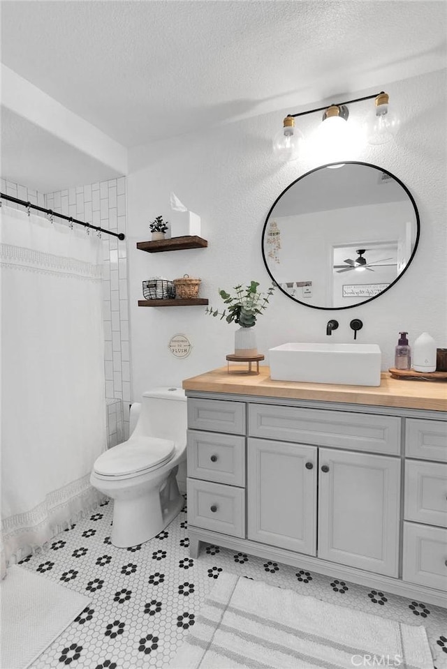 7733 Pismo Ave, Hesperia, CA 92345 - full bathroom with vanity, a ceiling fan, a textured ceiling, curtained shower, and tile patterned flooring