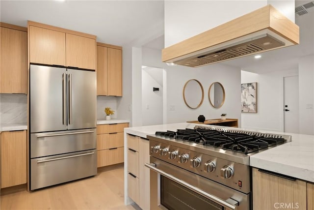 4282 Robbins St, San Diego, CA 92122 - kitchen with high quality appliances, light brown cabinets, premium range hood, light wood-type flooring, and light stone counters