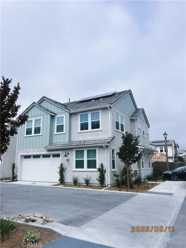 762 Jasper St, Mission Viejo, CA 92694 - view of front of house featuring an attached garage, roof mounted solar panels, concrete driveway, stucco siding, and board and batten siding