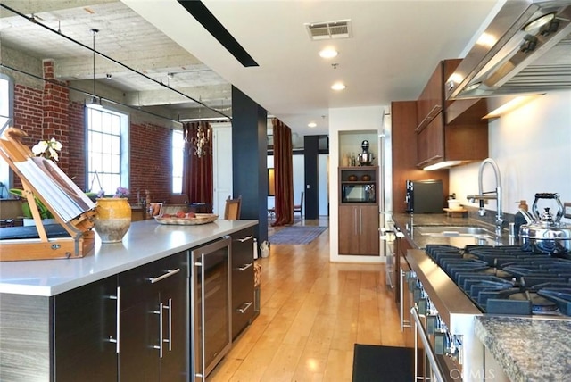 207 Broadway E Unit 302, Long Beach, CA 90802 - kitchen featuring wine cooler, exhaust hood, light wood finished floors, decorative light fixtures, and modern cabinets