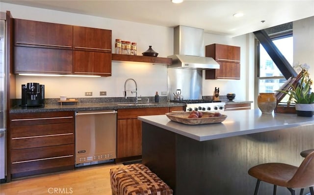 207 Broadway E Unit 302, Long Beach, CA 90802 - kitchen featuring dishwasher, wall chimney exhaust hood, a kitchen breakfast bar, open shelves, and light wood-style floors