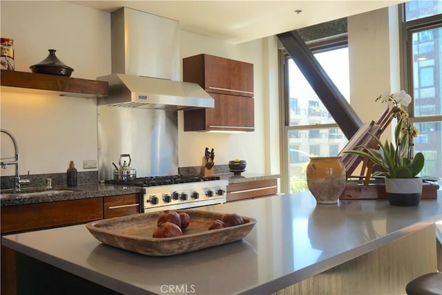 207 Broadway E Unit 302, Long Beach, CA 90802 - kitchen with wall chimney exhaust hood, gas range, brown cabinets, and modern cabinets