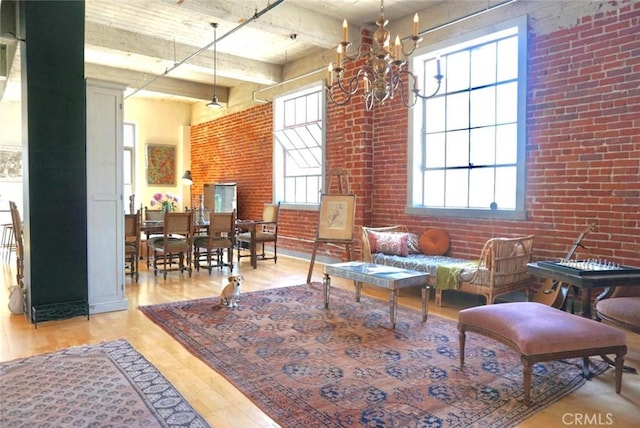 207 Broadway E Unit 302, Long Beach, CA 90802 - sitting room with brick wall, plenty of natural light, a chandelier, light wood finished floors, and a towering ceiling