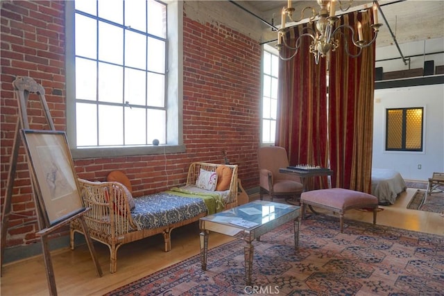 207 Broadway E Unit 302, Long Beach, CA 90802 - living area featuring wood finished floors, a chandelier, and brick wall