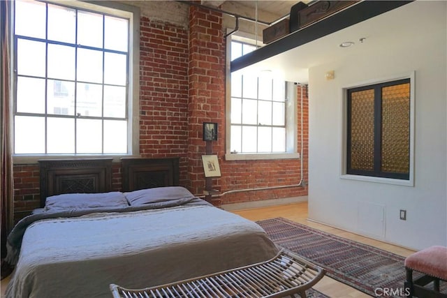 207 Broadway E Unit 302, Long Beach, CA 90802 - bedroom with multiple windows, brick wall, a fireplace, and wood finished floors