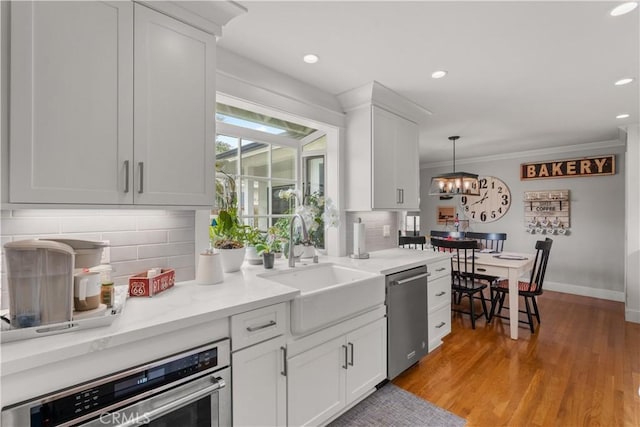1050 Marvista Ave, Seal Beach, CA 90740 - kitchen featuring stainless steel appliances, backsplash, white cabinetry, a chandelier, and pendant lighting