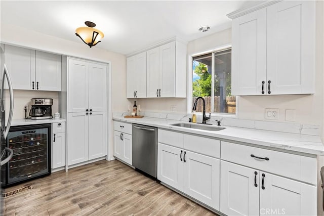 5655 Clearwater Dr, Yorba Linda, CA 92887 - kitchen with stainless steel dishwasher, wine cooler, white cabinetry, light wood-style flooring, and light stone countertops