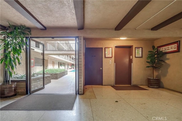 2501 W Redondo Beach Blvd Unit 306, Gardena, CA 90249 - entryway featuring elevator, beam ceiling, and speckle patterned floor