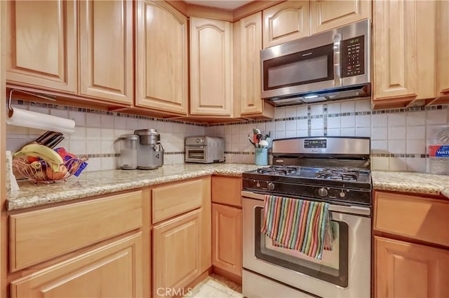 2501 W Redondo Beach Blvd Unit 306, Gardena, CA 90249 - kitchen featuring appliances with stainless steel finishes, light brown cabinetry, backsplash, and light stone counters