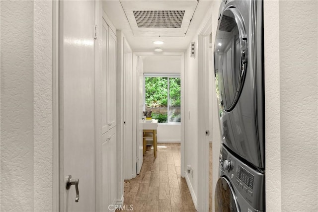 22709 Lakeway Dr Unit 493, Diamond Bar, CA 91765 - washroom with a textured wall, stacked washer and clothes dryer, and light wood-style floors