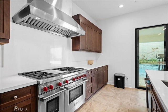 127 Interstellar, Irvine, CA 92618 - kitchen featuring wall chimney range hood, range with two ovens, light countertops, light tile patterned floors, and recessed lighting